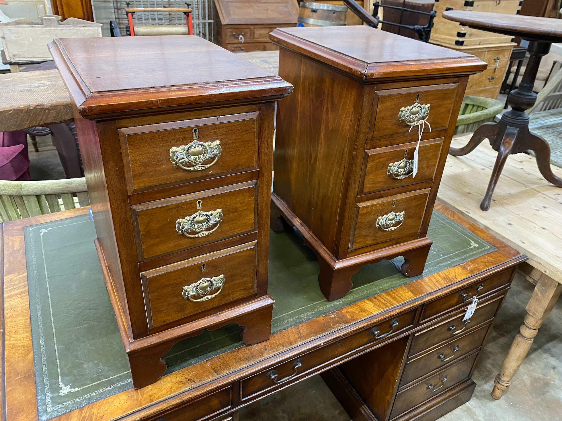 A pair of Edwardian and later mahogany three drawer bedside chests, altered, width 34cm, depth 44cm, height 64cm